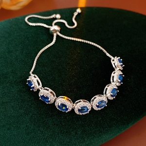 Détail d'un bracelet ajustable en argent avec sept zircons bleus de forme ovale