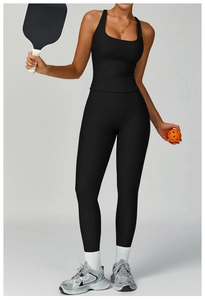 Detail of ribbed black yoga set featuring a racerback tank and high waist leggings