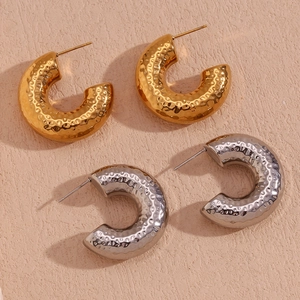 Detail of 18K gold and silver plated C-hoop earrings with hammered metal texture