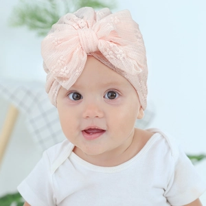Detailed view of breathable pink lace baby turban featuring a large elegant bow decoration