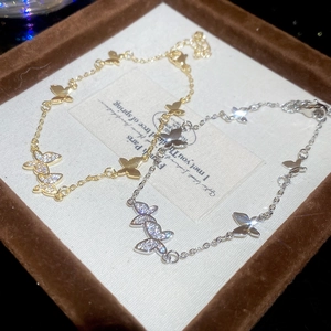 Detailed close-up of gold and silver butterfly bracelets with pavé cubic zirconia
