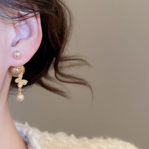 Macro shot of elegant champagne pearl earrings with crystal butterfly pendants for women