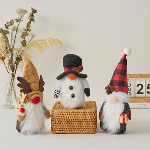 Three-piece set of Christmas gnomes with reindeer, snowman and plaid designs on a wooden table