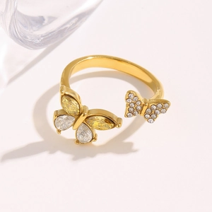 Detailed close-up of 18K gold butterfly ring with pear-cut yellow and white zircons