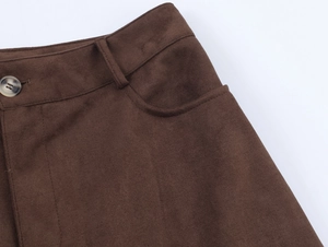 Close-up of brown faux suede trousers showing the button waist and texture detail