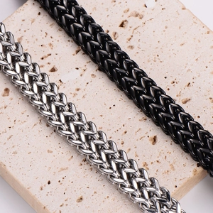 Macro detail of Spiga wheat chain bracelets in polished silver and matte black steel