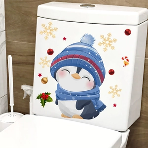 Close-up of cute penguin Christmas toilet sticker on white tank with snowflake decals