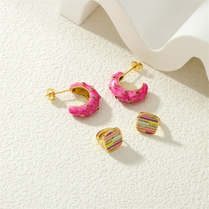 Detail of pink enamel hoop earrings and gold square studs with colorful zircons