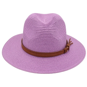 Close-up of purple woven straw Fedora hat with brown leather band and metal buckle detail