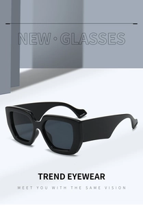 Detail view of bold black square sunglasses with thick temples and dark gray lenses