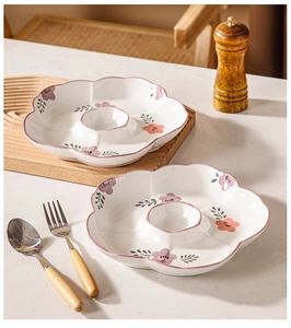 Detail of petal-shaped ceramic plates with pink floral patterns and built-in sauce compartment