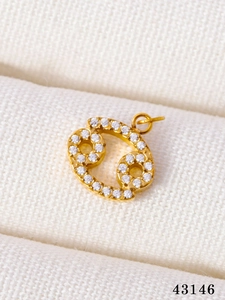 Detailed macro view of gold Cancer zodiac pendant with micro-pave cubic zirconia crystals
