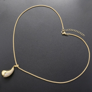 Vue macro d'un pendentif goutte en plaqué or avec pavé de zircons sur une chaîne élégante