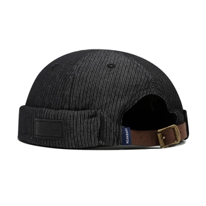 Bonnet docker rétro en denim noir avec sangle en cuir réglable et boucle sur fond blanc