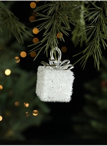 Sparkling white Christmas gift box ornament with silver bow hanging on tree