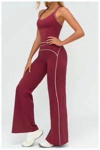 Detail of burgundy high-waisted flared sports pants with white contrast piping stitch