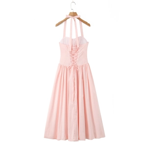 Detail of pink halter dress featuring backless criss-cross straps and pleated fabric