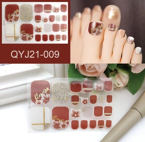Detail of waterproof toe nail wraps with red-brown, gold glitter and floral patterns