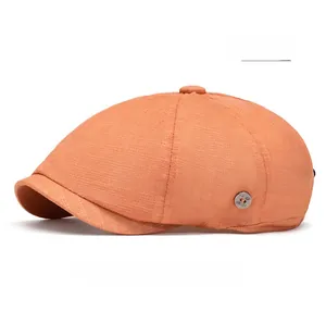 Detail of an orange newsboy cap featuring breathable honeycomb fabric and a metal button