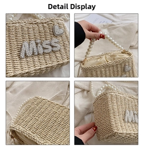 Detail showing pearl handles and MISS lettering on a woven straw beach handbag
