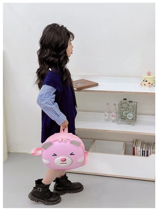 Toddler girl wearing pink cartoon bear backpack for school in a minimalist setting