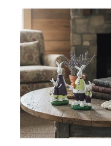Detail of hand-painted resin rabbit family figurines on a rustic wooden table
