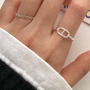 Macro shot of 925 sterling silver beaded ring and vintage oval chain link design on hand