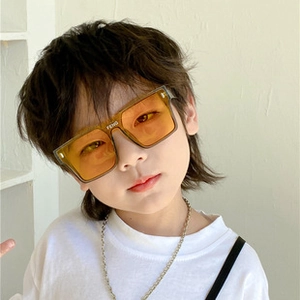 Detail shot of square orange sunglasses with FENG logo and silver metal chain accessory