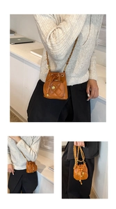Close-up of brown quilted leather bucket bag with chain strap and camellia flower detail