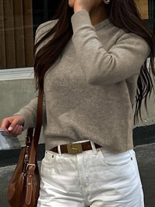Dettaglio di un maglione in maglia beige a maniche lunghe con girocollo in stile street