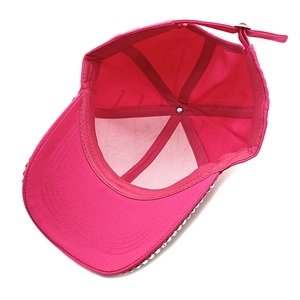 Detail view of pink cotton baseball cap interior with rivets and adjustable strap