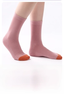 Dettaglio di calze in maglia a contrasto rosa e arancio con polsini a coste e trama verticale