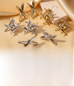 Detailed macro view of geometric crisscross earrings with polished spheres in gold finish