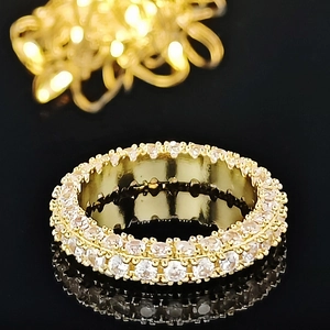 Close-up of golden wide eternity ring featuring multi-row pave round-cut zircons