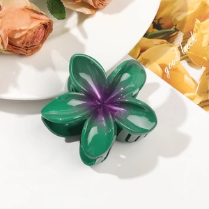 Detailed view of a dark green flower hair claw with purple gradient and glossy finish