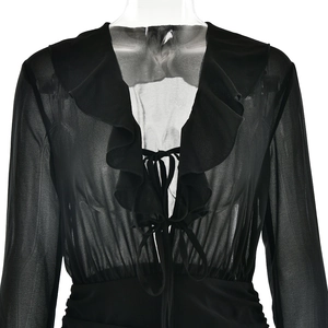 Detail of V-neck chiffon dress with ruffle trim and lace-up front on a black mesh sleeve