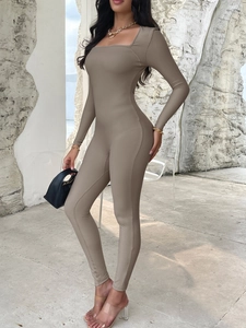 Professional fit of brown long sleeve ribbed yoga jumpsuit in a minimalist setting