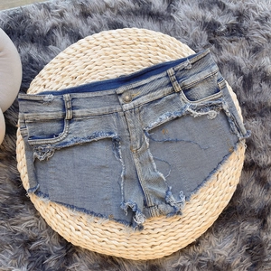 Flachbild von hellblauen Destroyed-Denim-Hotpants mit ausgefransten Kanten auf Matte