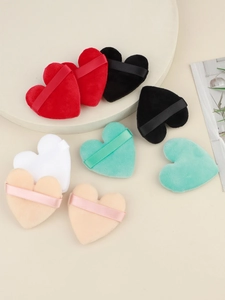 Macro shot of multi-colored heart-shaped flocked powder puffs with ribbon handle