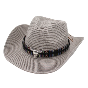 Light gray woven straw cowboy hat with ethnic band, bull skull charm, and side feathers