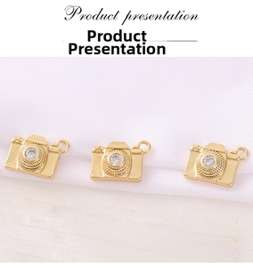 Detailed view of three gold-plated camera charms with cubic zirconia for DIY jewelry