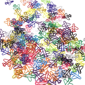 Detailed view of colorful airplane shaped paper clips scattered on a white background