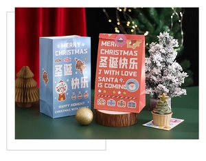 Close-up of red and blue paper Christmas gift bags with festive holiday decorations