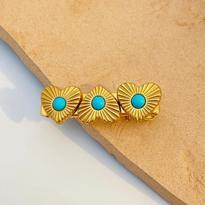 Detail of vintage 18k gold hair clip with three heart shapes and turquoise beads