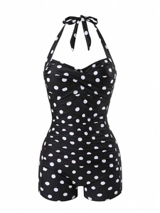 Detail of black one-piece swimsuit with white polka dots and tummy control ruching
