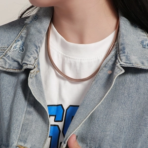 Rose gold snake bone chain necklace in polished stainless steel worn by a model