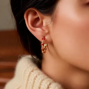 18k gold plated pig nose hoop earrings with red enamel and zircon accents on model
