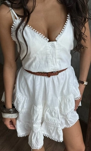 Λεπτομέρεια λευκού boho φορέματος με δαντέλα και κλιμακωτό τελείωμα στη φούστα