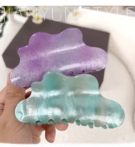 Detail of elegant cloud-shaped hair claws in purple and green with glitter finish