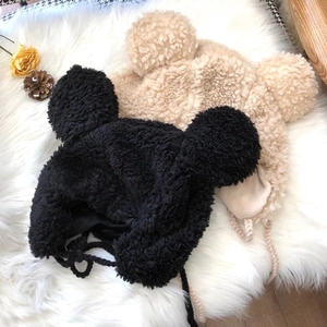 Cute plush earflap hat with round ears and braided ties in black and beige colors